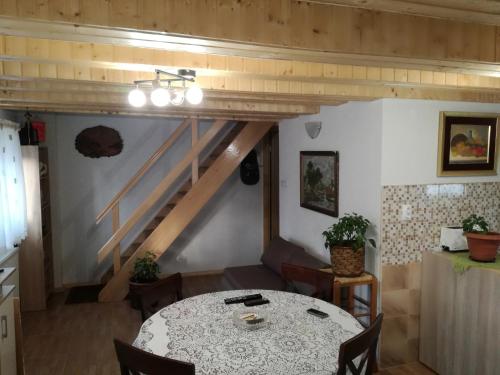 a dining room with a table and a staircase at Kuća za odmor "Jasna" (Holiday home "Jasna") in Crni Lug