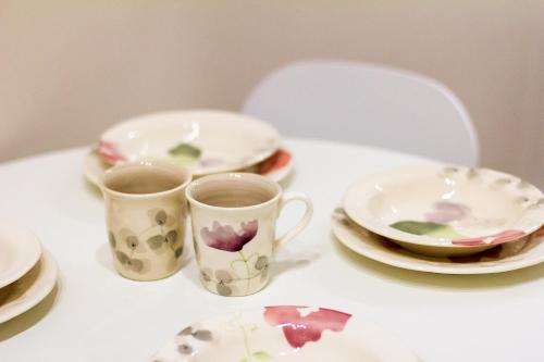 two cups and plates sitting on a table at Rose d'Opera Hotel in Odesa