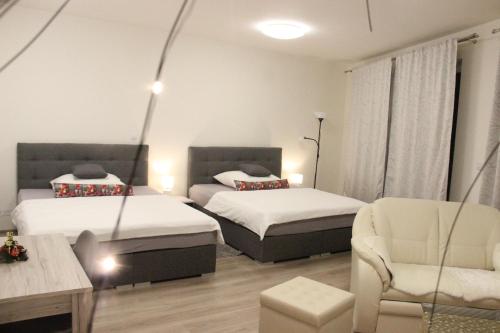 - une chambre avec deux lits, un canapé et une chaise dans l'établissement Element Prag Airport Apartment, à Prague