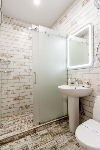 a bathroom with a sink and a toilet and a mirror at Rose d'Opera Hotel in Odesa