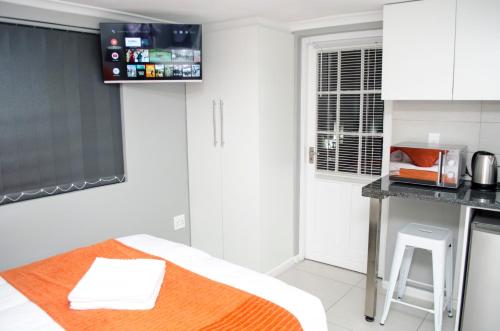 Una televisión o centro de entretenimiento en Cape Town Micro Apartments