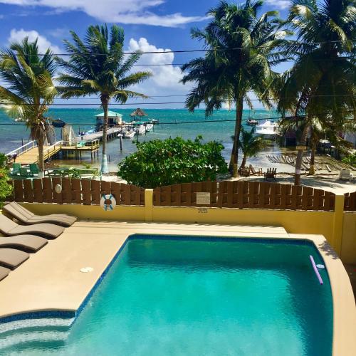 a swimming pool with a view of the beach at Caye Reef Condos in Caye Caulker