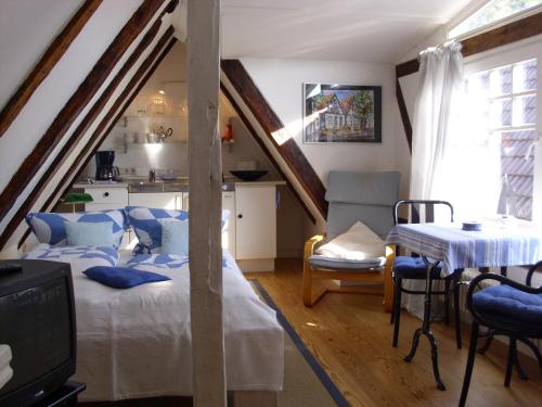 a attic room with a bed and a table at Haus Alexandrine in Warnemünde