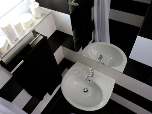 ハイドゥソボスローにあるSunset Apartmentsの白黒のバスルーム(シンク、鏡付)