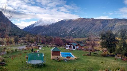 a group of huts in a field with mountains at Cabañas Emporio de la Meme in San José de Maipo