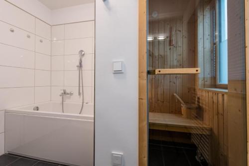 a bathroom with a bath tub and a shower at Haus Hafenblick in Olpenitz