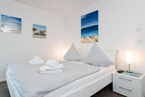 a bedroom with a white bed with towels on it at Haus Hafenblick in Olpenitz