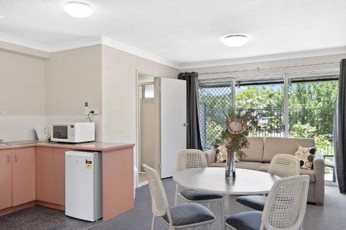 a kitchen and living room with a table and chairs at The Park Hotel Motel, Suffolk Park in Byron Bay