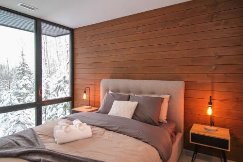 uma cama num quarto com uma parede de madeira em Chalet Métis em Petite-Rivière-Saint-François