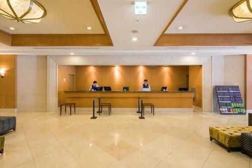 two people in a waiting room in a hotel lobby at HOTEL MYSTAYS Matsuyama in Matsuyama