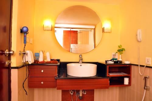 a bathroom with a sink and a mirror at Gokulam Park Sabari-Siruseri SIPCOT in Chennai