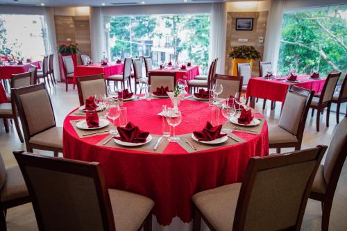 河內的住宿－Nesta Hotel Hanoi，一间设有桌椅和红色桌布的房间