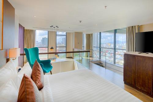 a bedroom with a large bed and a television at New Orient Hotel Da Nang in Da Nang