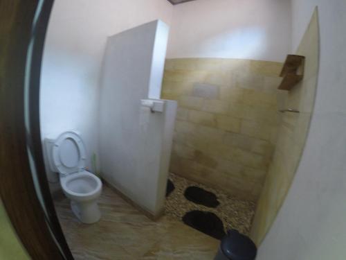 a small bathroom with a toilet and a shower at Rumah Made in Amed
