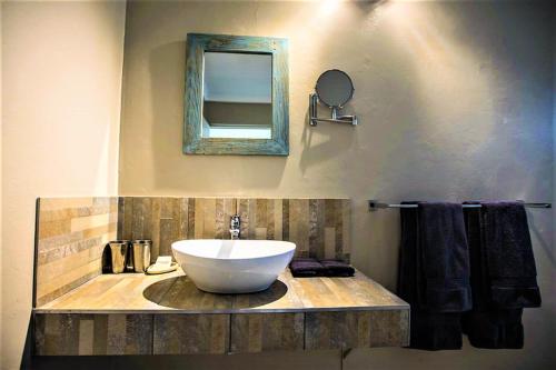 La salle de bains est pourvue d'un lavabo et d'un miroir. dans l'établissement The Waterfront, Maun, à Maun
