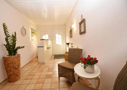 a living room with a table and a refrigerator at Hotel-Pension Anjo in Büsum