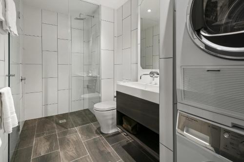 biała łazienka z toaletą i umywalką w obiekcie Quest Canberra City Walk w mieście Canberra