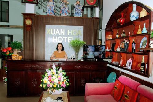 a woman sitting at a reception desk in a hotel room at Xuan Hoa Hotel in Ninh Binh