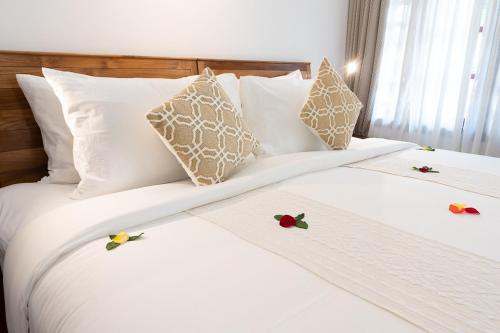 Dos camas en una habitación de hotel con flores. en The Ayur Villa en Kovalam