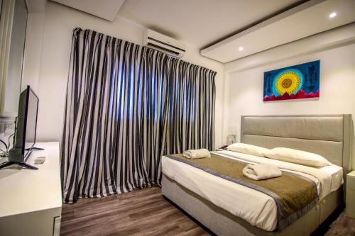 1 dormitorio con cama y ventana grande en Clock Inn Colombo, en Colombo