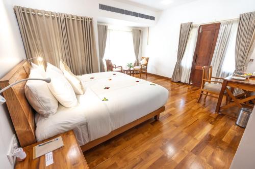 a bedroom with a large bed with white sheets and pillows at The Ayur Villa in Kovalam