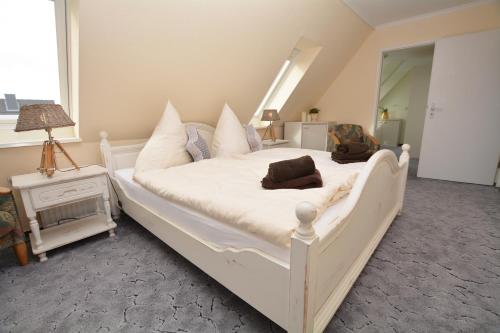 a bedroom with a large white bed with pillows at Hotel-Pension Anjo in Büsum