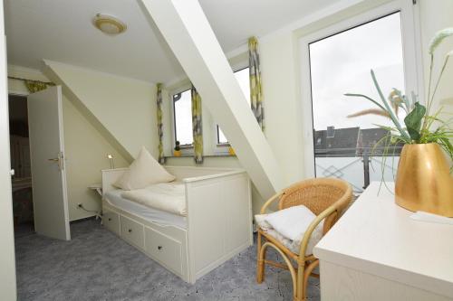 a small room with a bed and a window at Hotel-Pension Anjo in Büsum