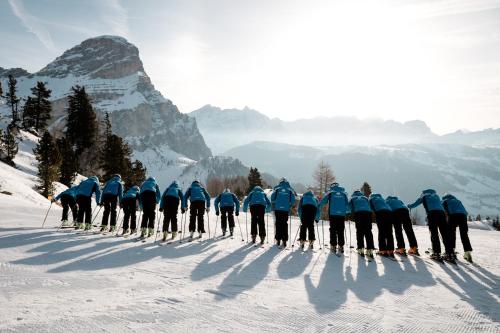 a group of people on skis in the snow at Residence Costa Burjada in Colfosco