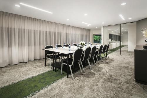 a conference room with a long table and chairs at Quest Canberra City Walk in Canberra