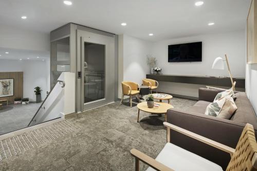 a living room with a couch and a table at Quest Canberra City Walk in Canberra