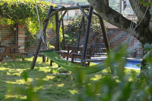 a hammock in a garden with two benches at Gengmengyuan B&B in Xikou