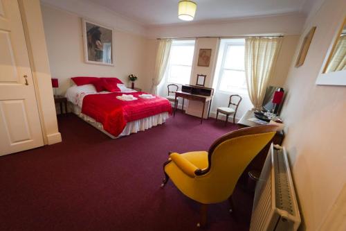 a bedroom with a bed and a desk and a chair at The Angel Hotel in Helston