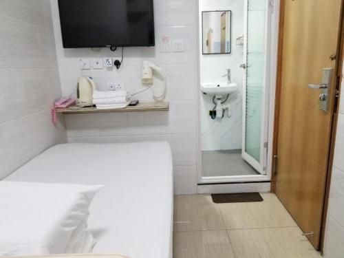 uma casa de banho com uma cama, um lavatório e um chuveiro em Asia Travel House em Hong Kong