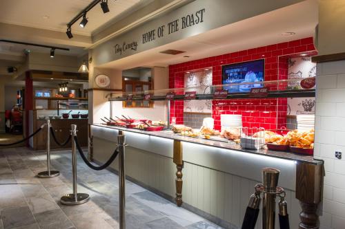 a bakery with a counter with bread and pastries at Toby Carvery Beckenham by Innkeeper's Collection in Bromley