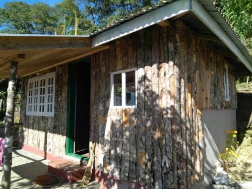 a log cabin with a door and a window at Vamoose Red Panda in Sombāri