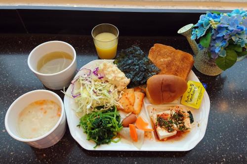 a plate of food with a sandwich and vegetables and a drink at Toyoko Inn Seoul Dongdaemun II in Seoul