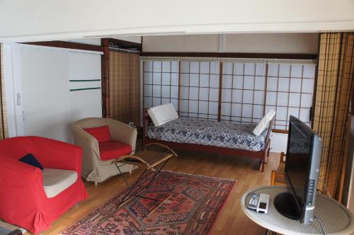 - un salon avec un lit et une télévision dans l'établissement EMS Enoshima ゲストハウス PetOK, à Fujisawa