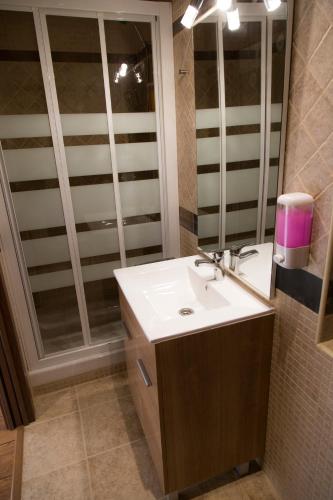 a bathroom with a sink and a mirror at Apartamentos "Casa Rural de Aldea" in Aldea del Fresno