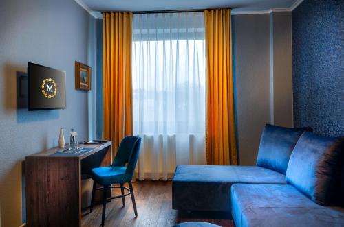 a living room with a couch and a desk with a chair at Monopol Boutique Hotel in Bremen