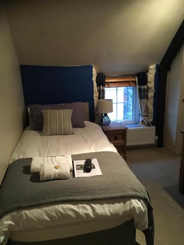 sypialnia z dużym łóżkiem i oknem w obiekcie The Tanners Arms w mieście Devynock
