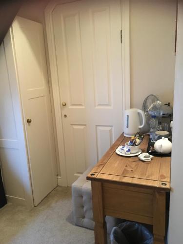 a room with a wooden table with a coffee maker on it at The Tanners Arms in Devynock