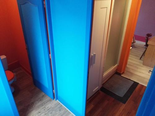 a blue door in a room with a hallway at L'Hôtel du Mouton blanc in Fresne-Saint-Mamès