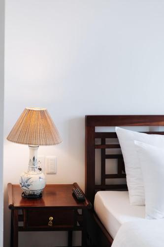 a lamp on a table next to a bed at VietHome-Doorstep to Hoan Kiem Lake in Hanoi
