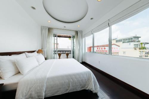 a bedroom with a large bed and a large window at VietHome-Doorstep to Hoan Kiem Lake in Hanoi