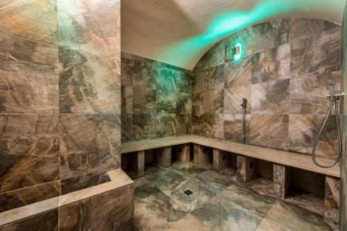 a bathroom with a shower with a bench in it at Relais Vignale & Spa in Radda in Chianti