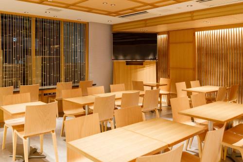 a classroom with tables and chairs and a projection screen at Tosei Hotel Cocone Ueno in Tokyo