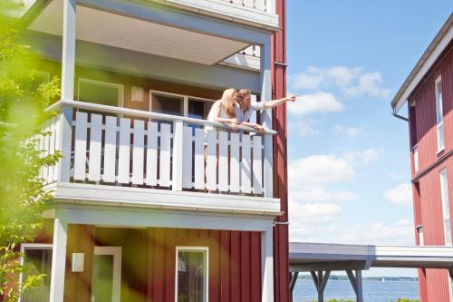 a woman on the balcony of a house at Ferienpark Müritz in Rechlin