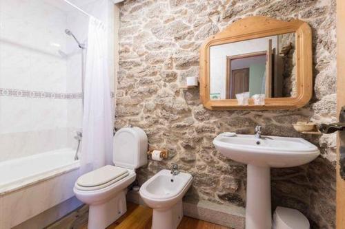 a bathroom with a sink and a toilet and a mirror at Casa Da Urcela in Ponteareas