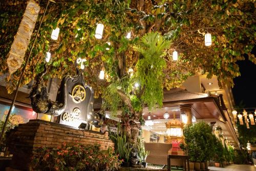 a shop with a clock on a brick wall with trees at At Chiang Mai - SHA Extra Plus in Chiang Mai