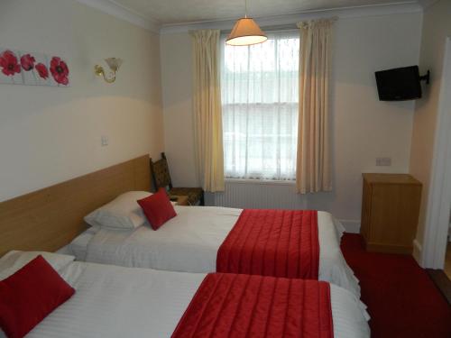 a hotel room with two beds and a window at The Cedars Hotel in Stowmarket